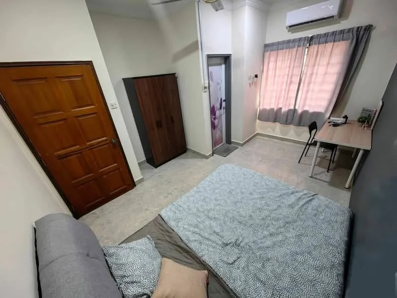 Bedroom features: queen-size bed with grey bedding, wooden door, built-in wardrobe with sliding doors, window with sheer curtains, wall-mounted air conditioning unit, study desk with chair, light grey tiled flooring, decorative wall with grey paint; style: modern.