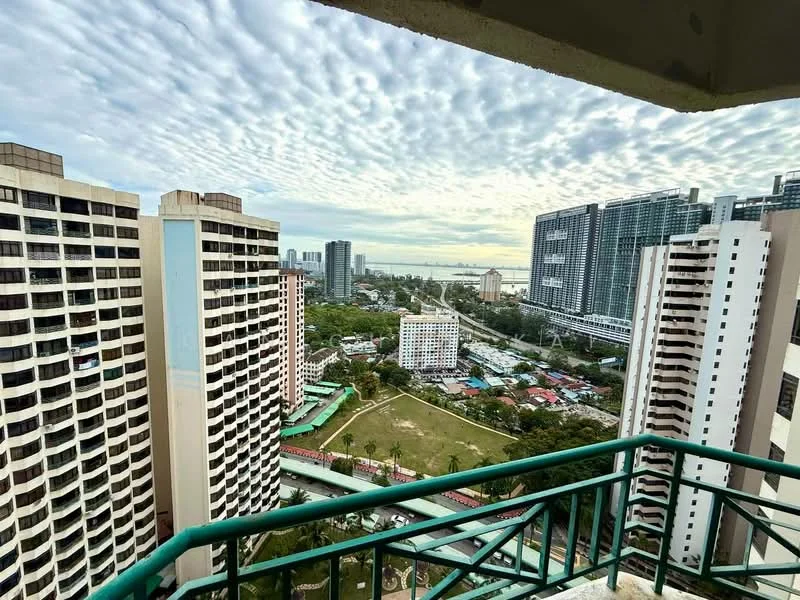Exterior type: high-rise condominium; features: city skyline view, surrounded by greenery, near waterfront, multiple high-rise buildings, balcony railing, cloudy sky, open space below, urban landscape; style: modern.
