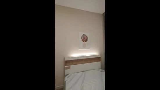 Bedroom features: light beige painted walls, wooden bed frame, white bedding, decorative wall art, LED strip lighting behind headboard; style: modern.