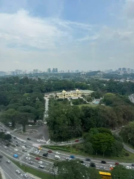 Exterior features: city skyline in background, greenery surrounding the area, road with traffic, large landscaped area, multiple lanes of traffic, urban setting.