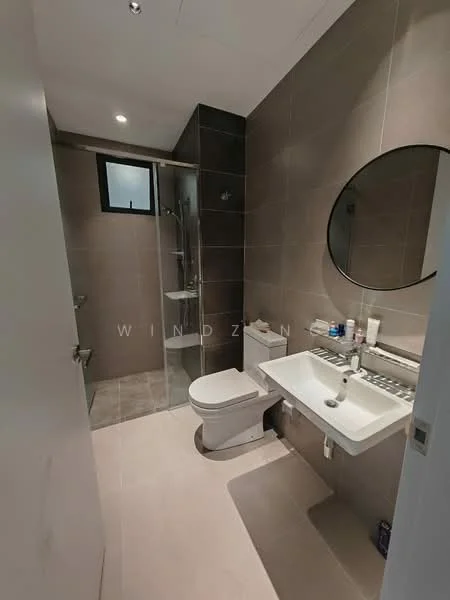 Bathroom features: grey tiled walls, light grey tiled flooring, walk-in shower with glass enclosure, chrome shower head, round mirror, single-sink vanity with white cabinet, toilet, wall-mounted faucet, window for natural light, recessed lighting; style: modern.
