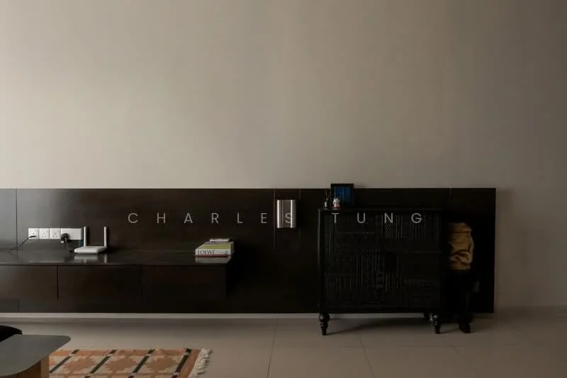 Room features: dark wood wall paneling, light beige walls, built-in wall shelf, decorative black cabinet, minimalist decor, electrical outlets, small decorative items, area rug with geometric pattern; style: modern.