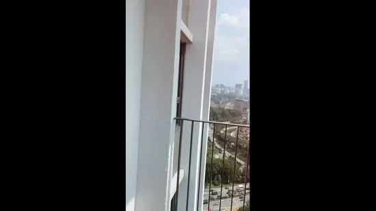 Room features: white painted walls, balcony with railing, city skyline view; view: city.