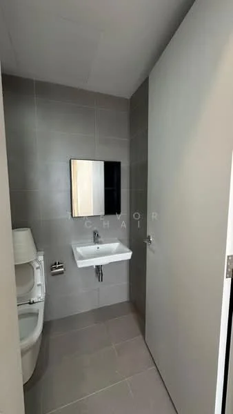 Bathroom features: grey tiled walls, grey tiled flooring, white wall-mounted sink, chrome faucet, framed mirror, one-piece toilet, minimalist design, single door, natural light from window, wall-mounted toilet paper holder; style: modern.