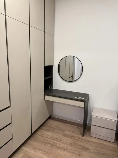 Room features: built-in wardrobe with beige panels, black trim on cabinetry, round mirror, floating desk with black surface, light wood flooring, small storage box, open shelving above desk; style: modern.