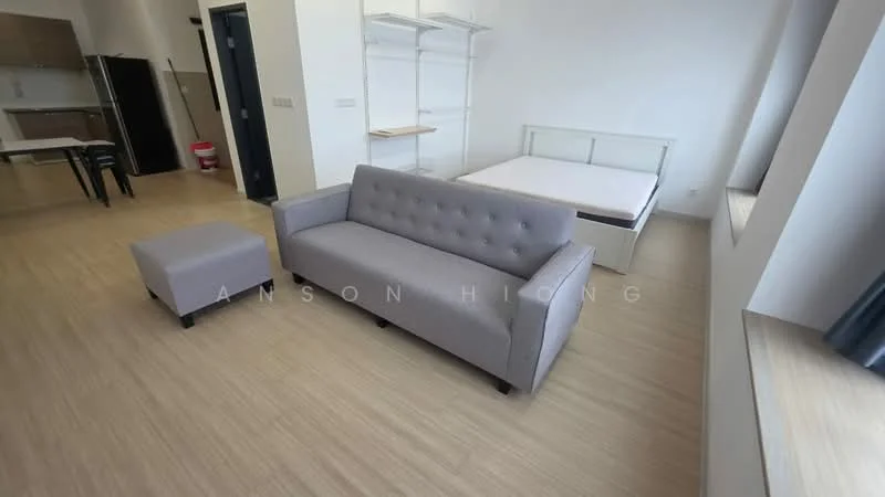 Living features: grey fabric 3-seater sofa, black ottoman, light wood flooring, large window with natural light, white walls, minimalist decor, open layout to kitchen, bed frame without mattress; style: modern.