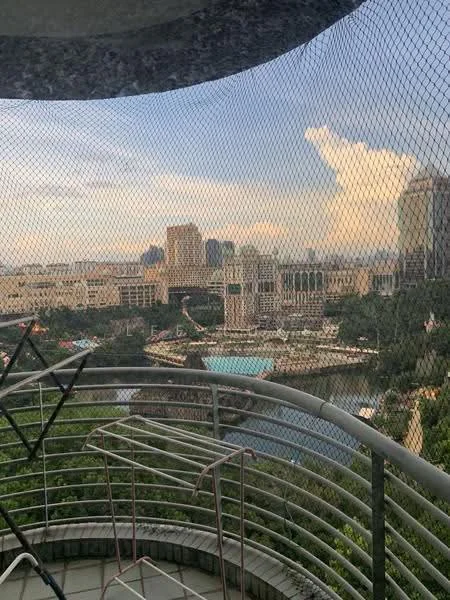 Balcony features: metal railing, concrete flooring, view of city skyline, netting for safety, outdoor drying rack; view: city.