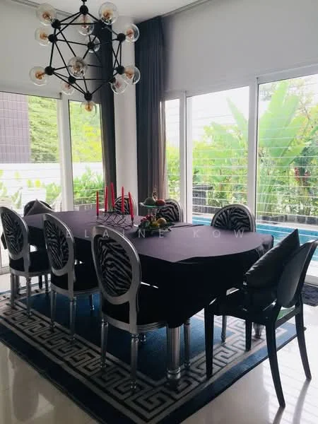 Dining features: 8-seater dining table with black tablecloth, black upholstered dining chairs, chandelier with multiple bulbs, large windows with sheer curtains, greenery view from windows, decorative centerpiece on table, area rug with geometric pattern, black and white color scheme; style: modern; view: garden.