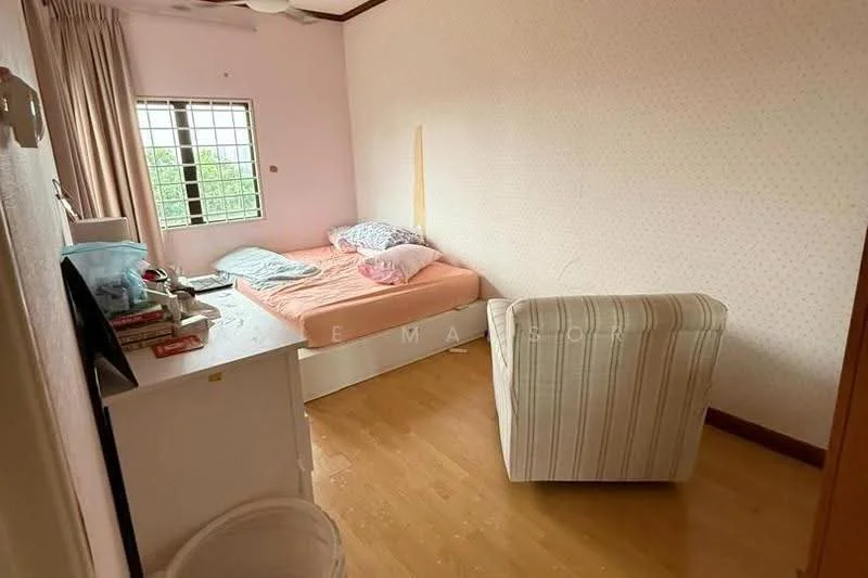 Bedroom features: pink painted walls, wooden flooring, single bed with pink bedding, two pillows, white armchair, window with grid pattern, ceiling fan, small white bedside table, books stacked on bedside table, wastebasket.