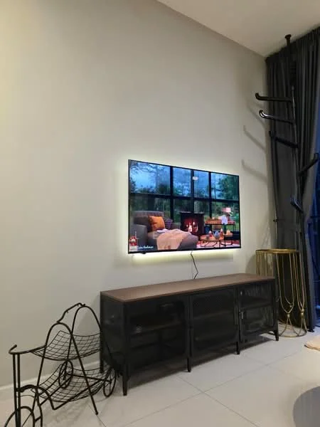 Living features: wall-mounted TV, black metal TV console, light wood TV cabinet, white painted walls, large windows with black frames, grey curtains, decorative metal stand, white tile flooring; style: modern.
