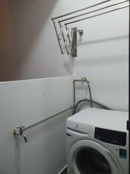 Laundry features: front-load washing machine, wall-mounted drying rack, white walls, plumbing fixtures, grey hose, metal wall-mounted rack.