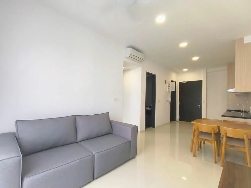 Living features: grey fabric sofa, dining table with wooden legs, 4 wooden dining chairs, white painted walls, glossy tile flooring, recessed LED downlights, wall-mounted split AC, open layout, kitchenette area visible; style: modern.