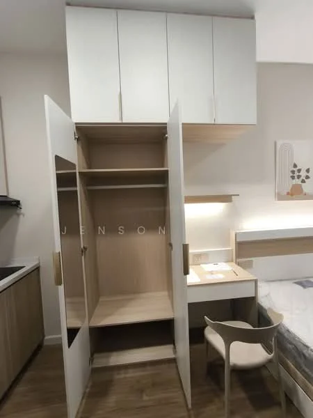 Room features: built-in wardrobe with sliding doors, light wood cabinetry, white upper cabinets, desk with lamp, wooden flooring, wall-mounted light fixture, neutral wall color, bed with bedding; style: modern.
