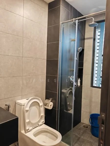 Bathroom features: grey ceramic tile flooring, light grey wall tiles, dark grey accent wall, walk-in shower with glass enclosure, rain shower head, handheld shower, one-piece toilet, chrome basin mixer faucet, toilet paper holder, window with vertical blinds, blue plastic bucket; style: modern.