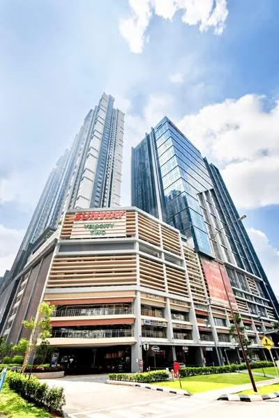 Exterior type: high-rise condominium; features: glass curtain wall, exposed concrete facade, recessed balconies, multiple storeys, commercial space at ground level, landscaped surroundings, manicured lawn, paved walkway; style: modern.