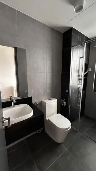 Bathroom features: grey tiled walls, black tiled accent wall, walk-in shower with glass enclosure, chrome handheld shower, single-sink vanity with black cabinet, white ceramic sink, one-piece toilet, mirror above vanity, recessed lighting, dark grey floor tiles; style: modern.