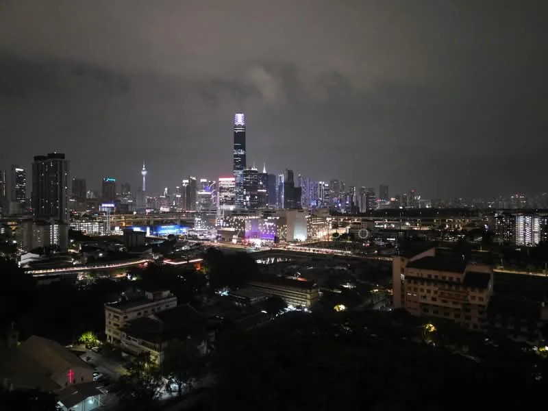 Exterior features: city skyline at night, illuminated buildings, high-rise structures, urban landscape, visible roadways, night sky with clouds; style: modern.