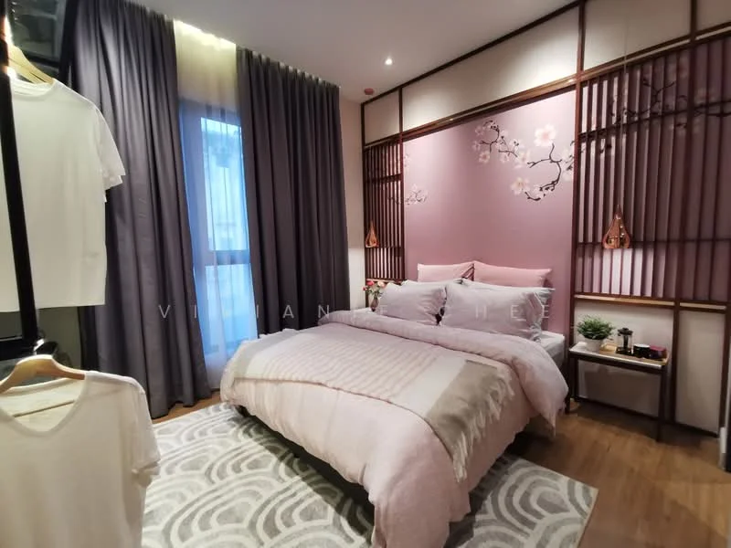Bedroom features: king-size bed with pink bedding, upholstered headboard, wooden bedside table, decorative wall paneling with floral design, floor-to-ceiling window with sheer curtains, grey curtains, area rug with geometric pattern, wall-mounted light fixtures, decorative plants, clothing rack with hanging shirts; style: modern.