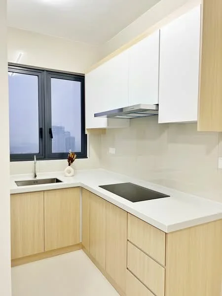 Kitchen features: white cabinetry with flat-panel design, light wood lower cabinets, white quartz countertop, single-bowl stainless-steel sink, chrome pull-down faucet, built-in stainless-steel range hood, ceramic cooktop, wall-mounted cabinets, large window with black frame, neutral wall color, light-colored flooring; style: modern; view: city.