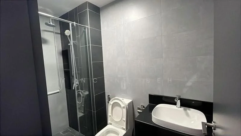 Bathroom features: grey tiled walls, black countertop, white sink, chrome faucet, one-piece toilet, walk-in shower with glass enclosure, shower head, sliding shower door, dark grey floor tiles; style: modern.