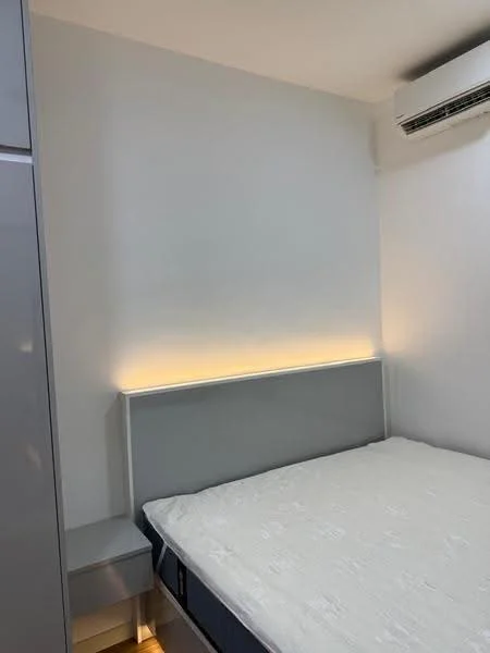 Bedroom features: queen-size bed, upholstered headboard with LED lighting, white painted walls, built-in wardrobe with grey finish, wall-mounted air conditioning unit, nightstand with drawer, light-colored bedding, laminate flooring; style: modern.