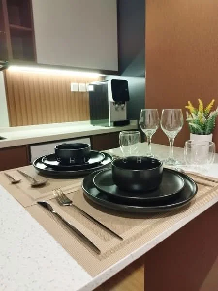 Kitchen features: black ceramic dinnerware, glass wine glasses, cutlery set, white quartz countertop, wooden cabinetry, built-in coffee machine, recessed lighting, textured wall paneling, decorative plant; style: modern.