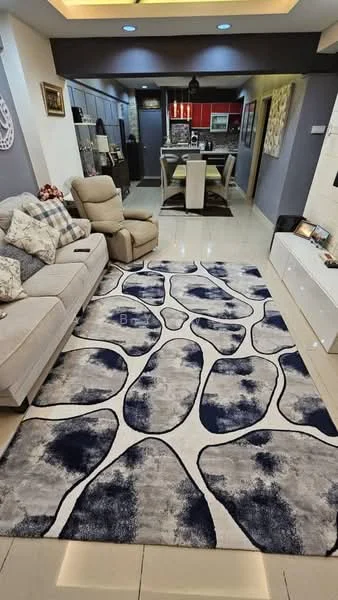 Living features: 3-seater fabric sofa in beige, decorative throw pillows, area rug with abstract pattern in navy and white, wall-mounted TV, TV console, recessed downlights, cream painted walls, tile flooring, open layout to dining area, decorative wall art, ceiling with cove lighting; style: modern. Dining features: 6-seater dining table, upholstered dining chairs, pendant lighting above dining table, red accent wall, open kitchen view; style: modern.