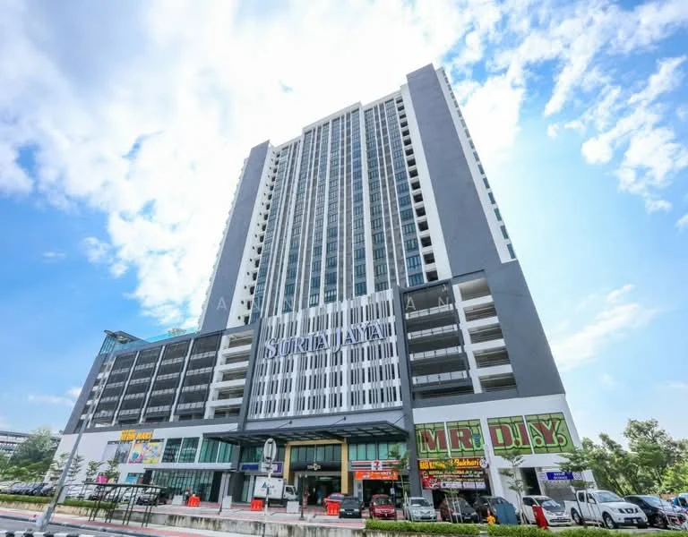 Exterior type: high-rise condominium; features: glass curtain wall, grey painted facade, recessed balconies, multiple storeys, commercial units at ground level, signage for shops, surrounding landscaping, parking area in front; style: modern.
