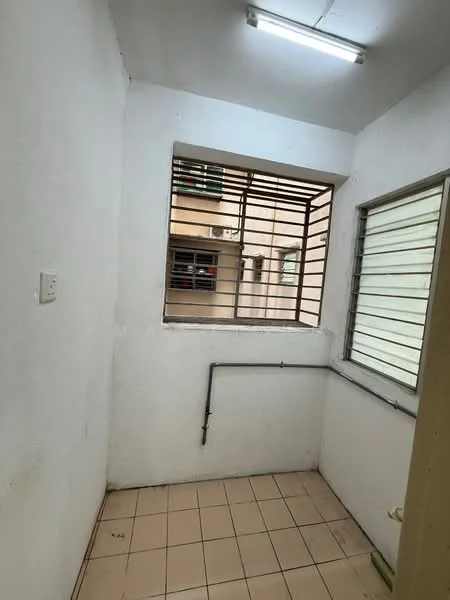 Room features: white painted walls, tile flooring, window with metal grille, window with horizontal slats, fluorescent ceiling light, corner space, exposed pipe.