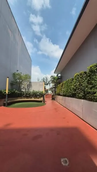 Exterior features: red rubberized flooring, landscaped planters with greenery, concrete walls, clear glass partition, potted plants, open sky view; style: modern.