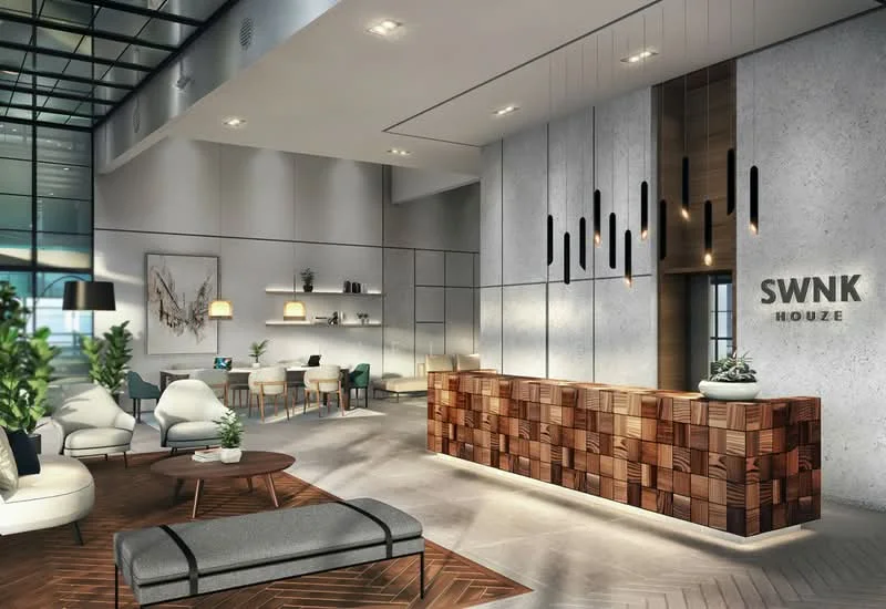 Lobby features: wooden reception desk with geometric design, modern pendant lighting, sofa with grey upholstery, armchairs in white upholstery, coffee table with dark wood finish, area rug with geometric pattern, wall-mounted artwork, shelves with decorative items, large windows with natural light, wood paneling on walls, recessed ceiling lights, greenery in pots; style: modern.