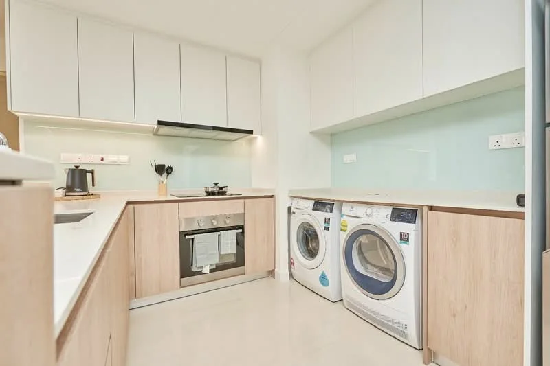 Kitchen features: white cabinetry, light wood cabinetry, white quartz countertop, stainless-steel built-in oven, stainless-steel gas hob, stainless-steel range hood, double-bowl stainless-steel sink, chrome pull-down faucet, white backsplash, two front-load washing machines, kettle, under-cabinet lighting, recessed downlights, ceramic tile flooring; style: modern.