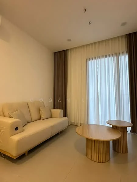 Living features: cream fabric sofa, 2 round wooden coffee tables, floor-to-ceiling windows, sheer curtains, light-colored walls, neutral tile flooring, recessed ceiling lights, decorative wall paneling; style: modern.