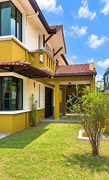 Exterior type: semi-detached house; features: double-storey, cream and yellow painted facade, projecting balconies, pitched tile roof, terracotta roof tiles, large corner windows, covered patio, stone-paved walkway, manicured lawn, young shrubs, surrounded by greenery, fronts a quiet residential street; style: contemporary.