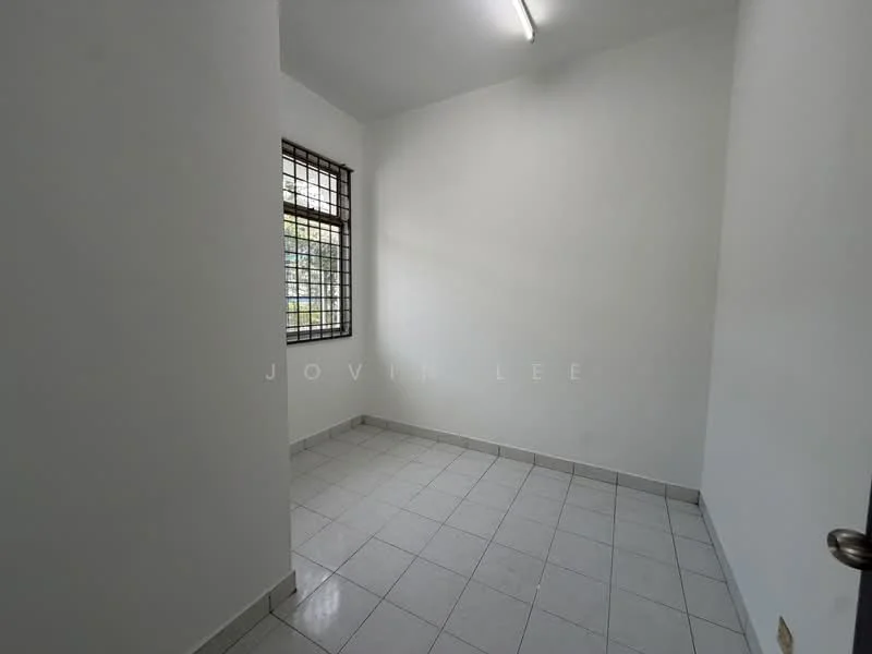Room features: white painted walls, tile flooring, square layout, single light fixture on ceiling, grilled windows, no visible furniture, neutral color scheme, corner room.