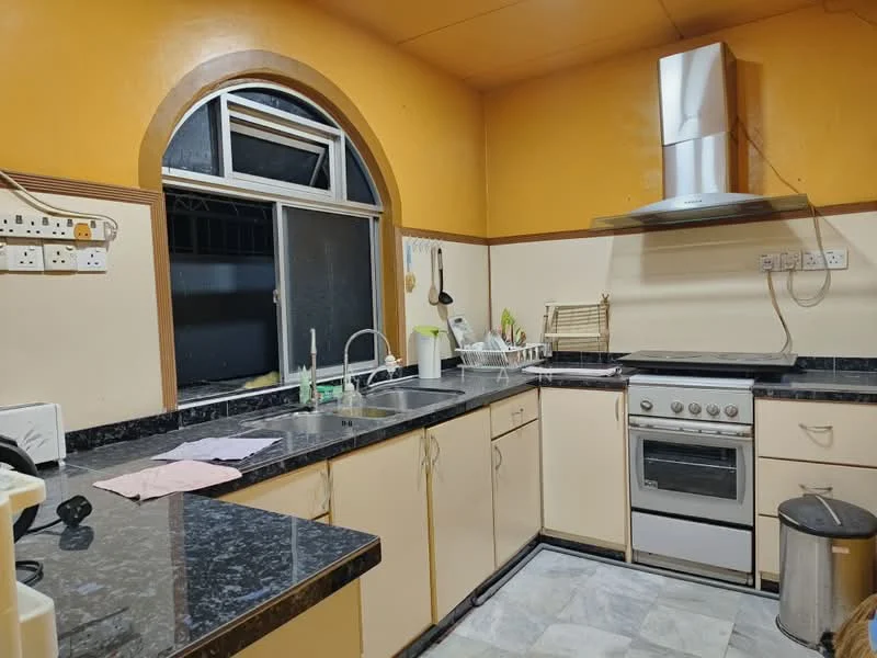 Kitchen features: black granite countertop, cream cabinetry, double-bowl stainless-steel sink, chrome pull-down faucet, built-in oven, 4-burner gas hob, stainless-steel range hood, window with arched design, tile flooring, kitchen utensils on countertop, dish rack, trash bin.