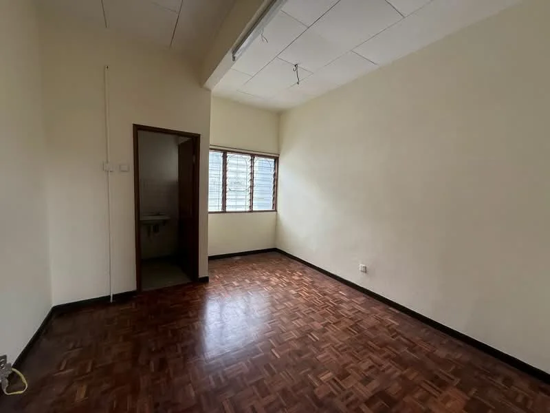 Room features: parquet wood flooring, cream painted walls, ceiling with recessed lighting, large window with multiple panes, doorway leading to bathroom, corner of room with no visible furniture.