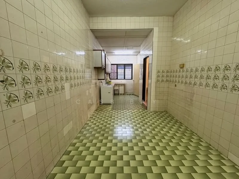 Kitchen features: green and white checkered tile flooring, white tiled walls, decorative tile border with floral pattern, built-in cabinetry, window with grid pattern, single-bowl sink, countertop space, doorway leading to another room.