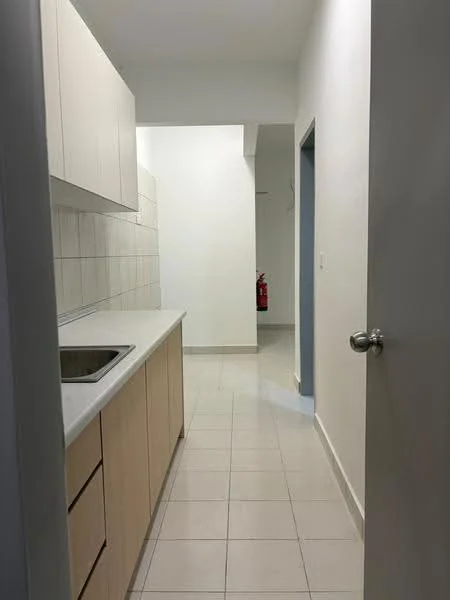 Room features: white painted walls, light grey floor tiles, kitchen cabinetry in light wood, single-bowl stainless-steel sink, countertop with smooth surface, no visible appliances, doorway leading to hallway, fire extinguisher visible in background; style: modern.