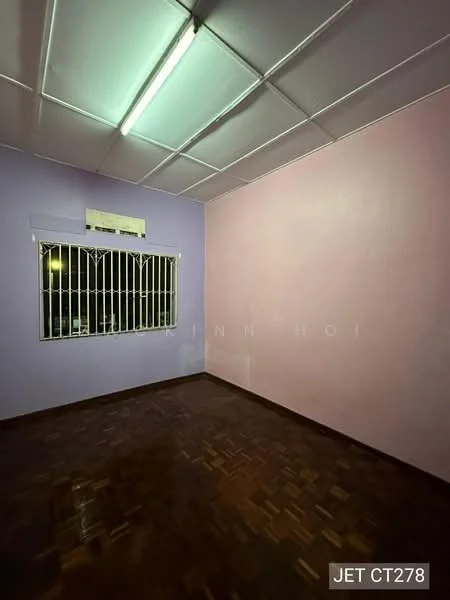 Room features: purple painted walls, light pink painted walls, wooden flooring, window with security bars, ceiling with fluorescent lighting, no visible furniture or decor.