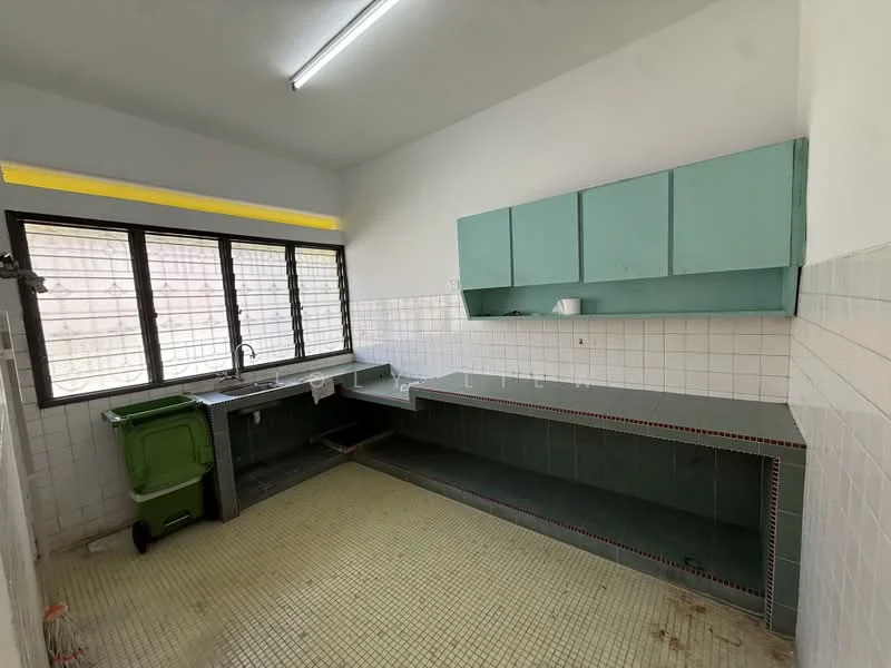 Kitchen features: green cabinetry, white tiled walls, grey countertop, single-bowl stainless-steel sink, window with metal grilles, floor tiles in yellow, overhead fluorescent lighting, open layout, built-in countertop space, garbage bin.