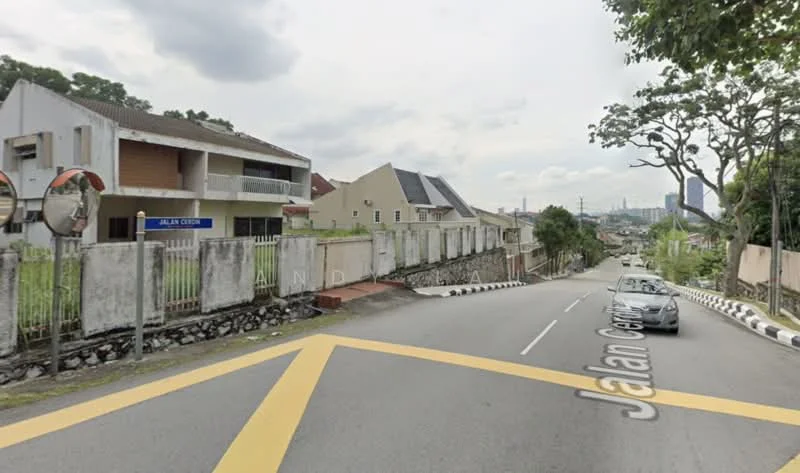 Exterior type: linked terrace house; features: two-storey building, white painted facade, sloping roof, front garden area, fenced property, paved driveway, street view with road markings, surrounded by greenery, adjacent to residential area; style: modern.