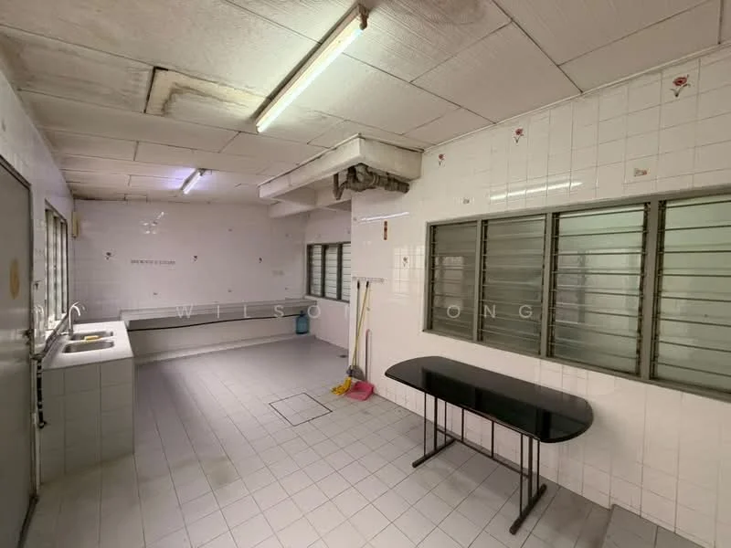 Laundry features: white tiled walls, white tiled flooring, two stainless-steel sinks, metal countertop, window with metal grilles, overhead fluorescent lighting, cleaning supplies visible, black table, floor drain.