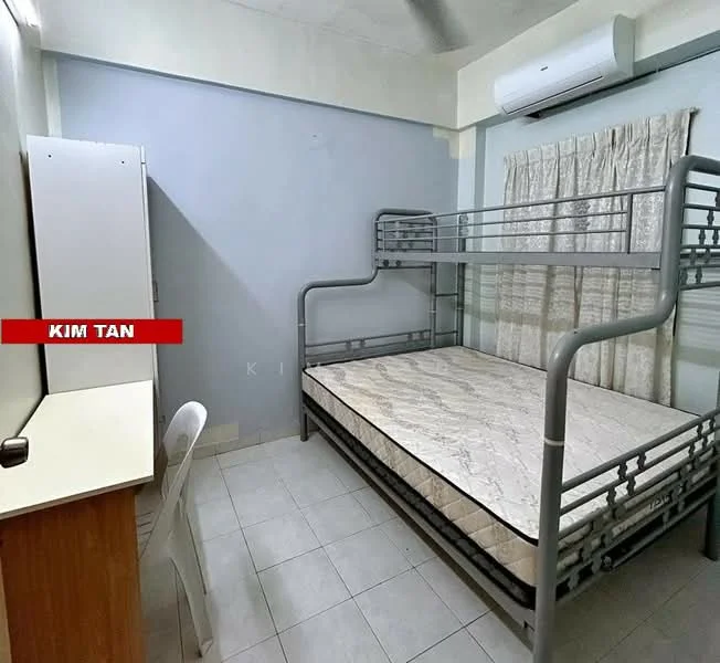 Bedroom features: bunk bed with metal frame, mattress on top and bottom bunk, study desk with white surface, plastic chair, curtains with floral pattern, wall-mounted air conditioning unit, light-colored painted walls, tiled flooring.