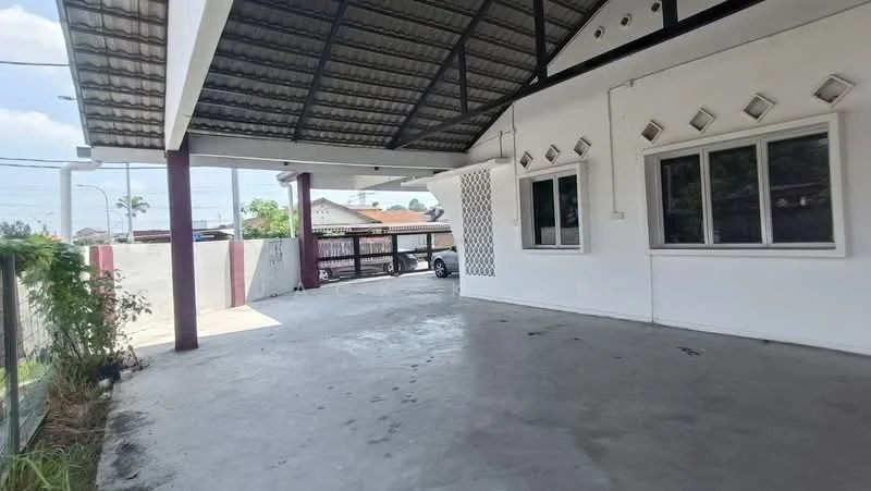 Exterior type: detached bungalow; features: covered car porch, concrete flooring, metal roof, white painted facade, decorative window grilles, open space, surrounded by low fencing, driveway access, mature greenery in background; style: modern.