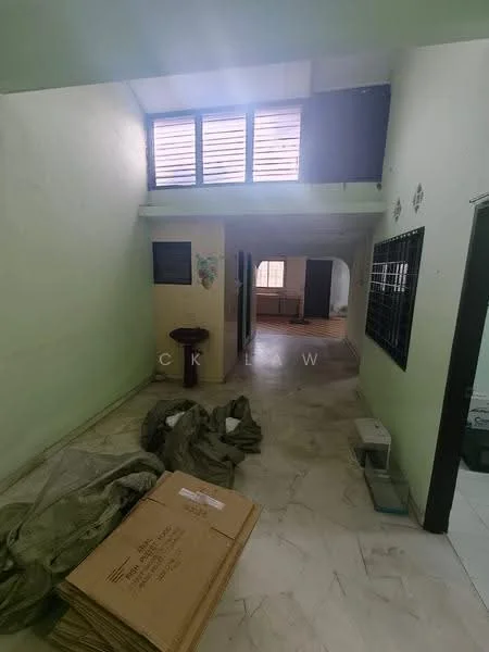 Room features: green painted walls, marble flooring, large windows with horizontal slats, open space layout, visible packing materials, doorway leading to another room, light source from windows, unfurnished space.