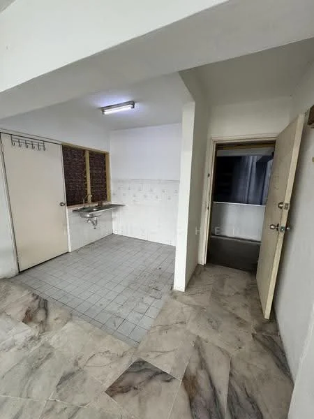 Room features: grey tiled flooring, white painted walls, single-bowl stainless-steel sink, wall-mounted faucet, tile backsplash, fluorescent ceiling light, door leading to another room, window with no visible treatment, corner wall with exposed brick, open space layout; style: minimalist.