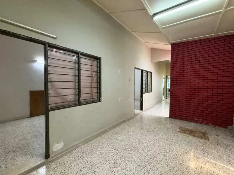 Room features: white painted walls, red brick accent wall, terrazzo flooring, sliding windows with metal grills, ceiling lights, open layout, doorway leading to another room, natural light from windows; style: modern.