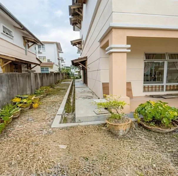 Exterior type: semi-detached house; features: two-storey building, cream painted facade, light brown accents, landscaped garden with potted plants, narrow side pathway, concrete walkway, windows with grilles, overhanging eaves, gutter system, fenced perimeter; style: modern.