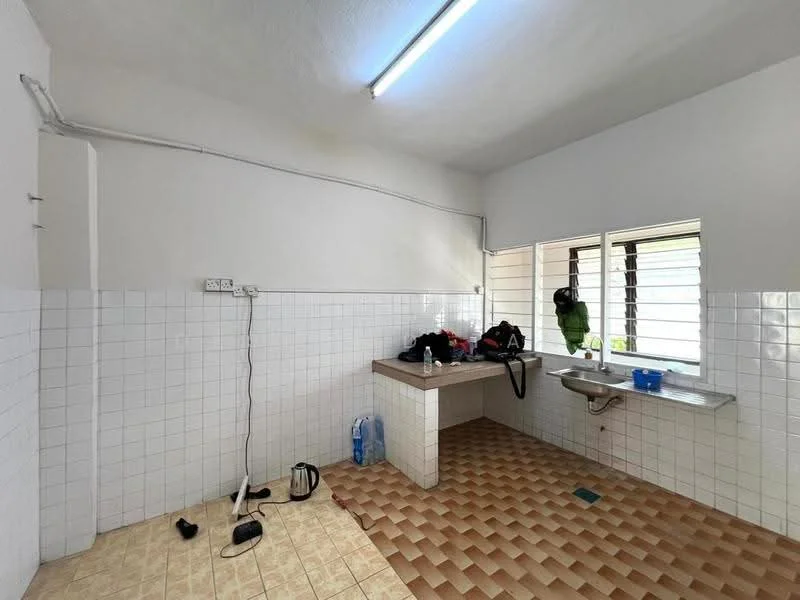 Kitchen features: white tiled walls, cream tiled flooring, single-bowl stainless-steel sink, chrome faucet, countertop with space for appliances, window with metal grille, overhead fluorescent lighting, electrical outlet on wall, cleaning supplies on countertop, floor space for additional storage.